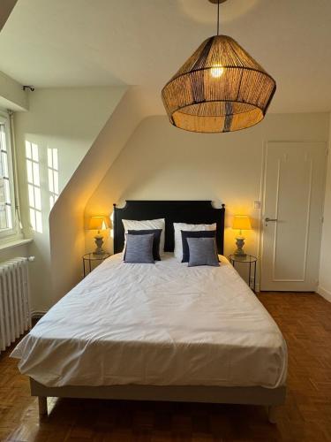 une chambre avec un grand lit blanc avec deux lampes dans l'établissement Maison Hyper centre Dinan 2,4 ou 6 personnes, à Dinan
