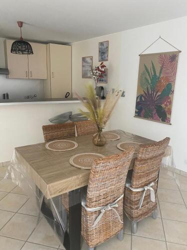 - une cuisine avec une table à manger et des chaises en osier dans l'établissement Maison indépendante en plein cœur de Dolus, à Dolus-d'Oléron