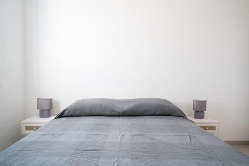 a bedroom with a bed with two nightstands and two lamps at Girasole in La Caletta