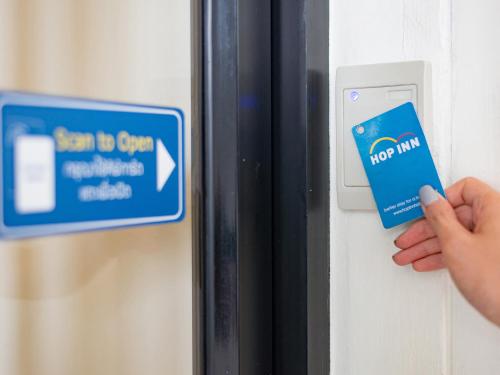 a person is unlocking a door with a credit card at HOP INN Songkhla in Songkhla