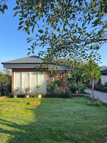 a house in a yard with a tree at Huyen's Home in Ba Ria