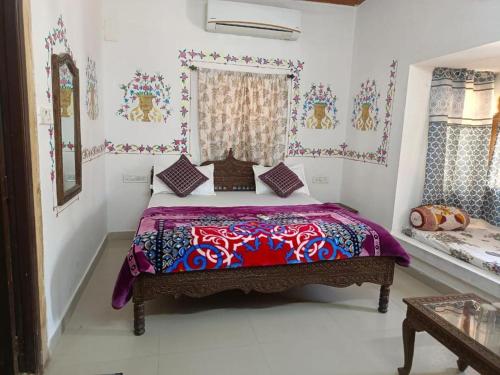 a bedroom with a bed with a colorful bedspread at Jimmy's Guest House &cafe in Jaisalmer