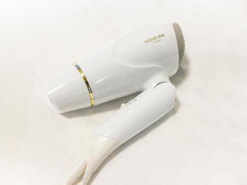 a white electric hair dryer on a white surface at Hearton Hotel Shinsaibashi Nagahoridouri in Osaka