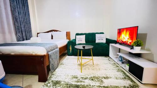 a bedroom with a bed and a green couch at Fully Furnished Studio Apt in Ruiru Membly, next to Drop n Shop Supermarket in Ruiru