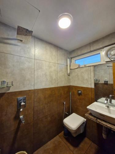 un baño con inodoro y lavabo en Enchanter Villa, en Vagamon
