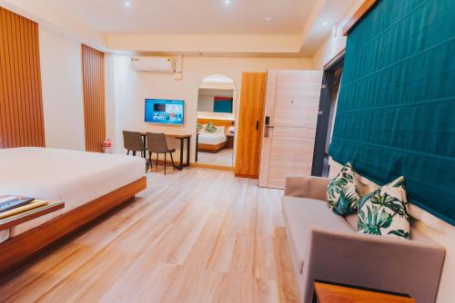 a hotel room with a bed and a couch at SureStay Studio by Best Western Clarkview Angeles City in Angeles