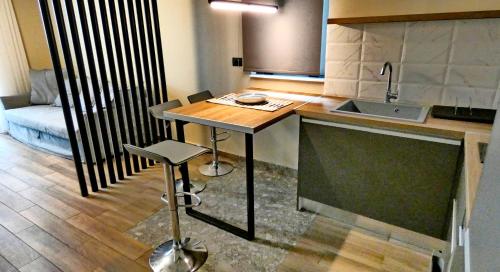 a small kitchen with a table and a sink at GoldenRoyalSuites in Stalos