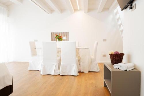a white room with white chairs and a table at Villa Puri nella Valle dei Laghi in Fratta