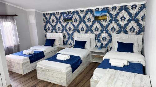 three beds in a room with blue wallpaper at Byurakan Guesthouse & Cottage in Byurakan
