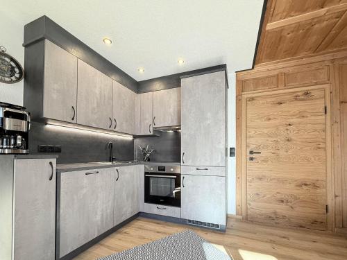 a kitchen with stainless steel appliances and wooden cabinets at Haus Carolus in Elbigenalp