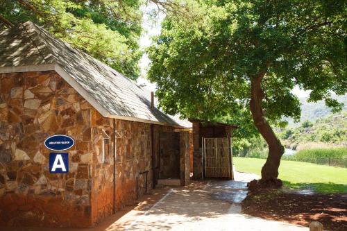 a stone building with a tree in front of it at Blyde Canyon, A Forever Resort in Matibidi