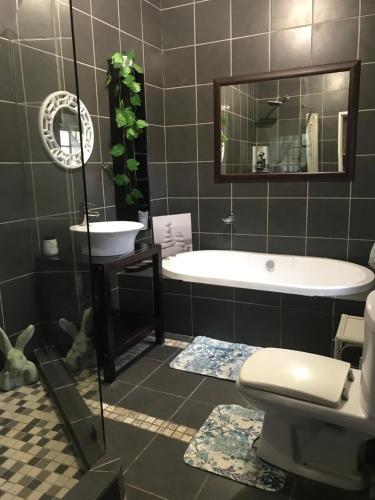 a bathroom with a tub and a toilet and a sink at Cottage on Kort Deluxe in Parys