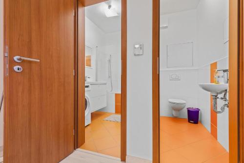 a bathroom with a toilet and a wooden door at AH Bosakova Elegant in Bratislava