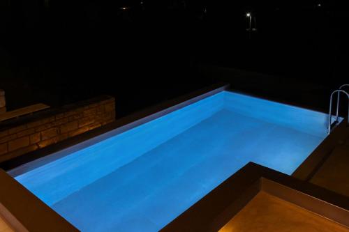 a blue swimming pool in a house at night at Amorelia Casa in Lefkogeia
