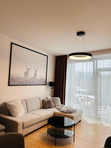 a living room with a couch and a table at Apartments Relax Tále in Evergreen Resort in Tale