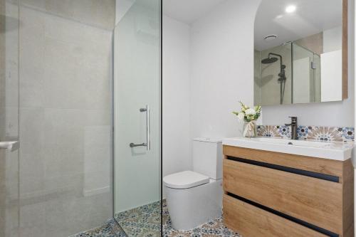a bathroom with a shower and a toilet and a sink at New build City Townhouse & Gated Car Park in Christchurch
