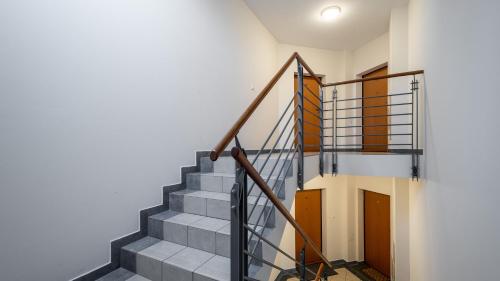 a staircase in a house with a metal railing at Wołodyjowskiego - Mokotów with jacuzzi, Sun & Snow in Warsaw