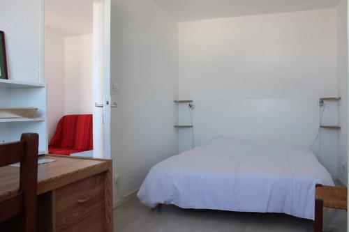 - une chambre avec un lit blanc et un bureau en bois dans l'établissement Appartement 2 pièces - LA ROCHELLE - LR240-602, à La Rochelle