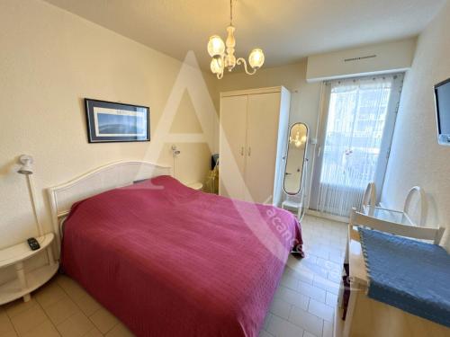 une chambre avec un grand lit avec une couverture violette dans l'établissement T2 1ERE LIGNE MER, PKG, WI-FI, DIRECT PLAGES, à Sète