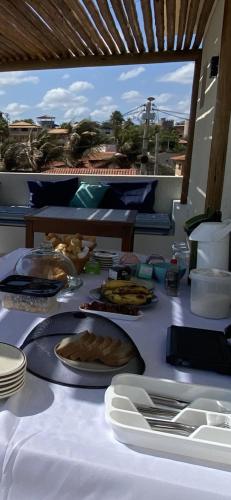 een tafel met daarop borden met eten bij Vila éden praia suítes in Canoa Quebrada