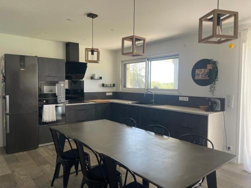 Il dispose d'une cuisine avec une table et des chaises. dans l'établissement Gîte à la ferme, à Saint-Martin-de-Seignanx