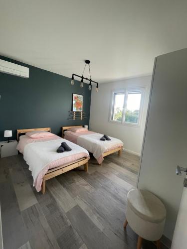 une chambre avec deux lits et un miroir dans l'établissement Gîte à la ferme, à Saint-Martin-de-Seignanx