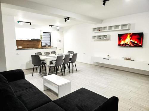 a living room with a couch and a table with chairs at RIA Duplex Ariniș in Gura Humorului