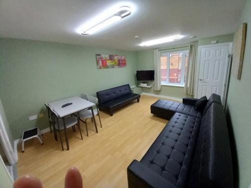 a living room with a couch and a table at Perfect for construction workers and building contractors in Manchester