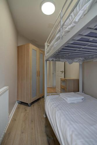 a bedroom with a bunk bed and a wooden floor at Perfect for construction workers and building contractors in Manchester