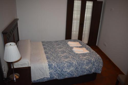 a bedroom with a bed with two towels on it at Apartamentos Bodeguetas in Constantina