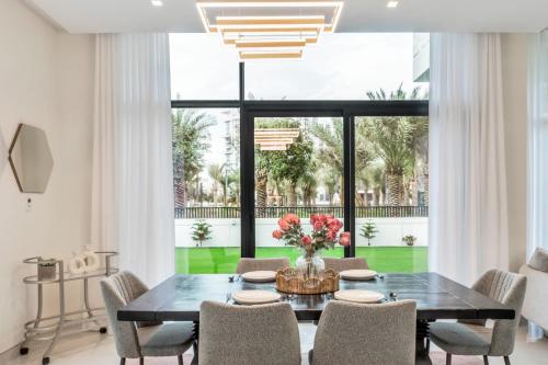 a dining room with a black table and chairs at Dubai Luxury 4BR Villa in Murooj Al Furjan in Dubai