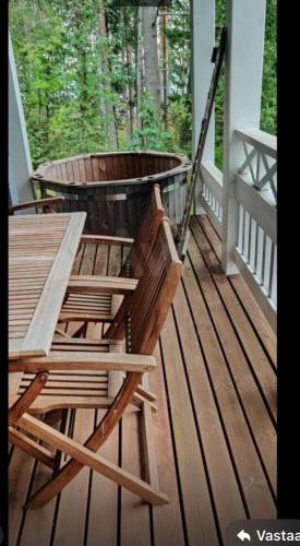 two chairs and a table on a porch at Villa Iltaranta - Cottage on the shore of Lake Saimaaa in Savonlinna