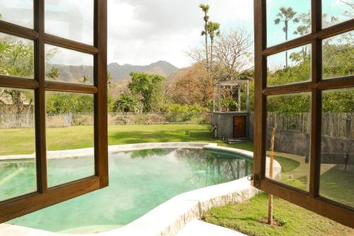 a view of a swimming pool from a window at Kalkun Villa Amed in Amed