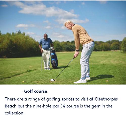 a man hitting a golf ball on a golf course at Haven cleethorpes beach holiday park in Cleethorpes