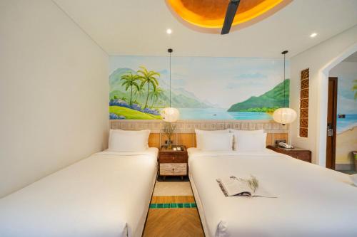 two beds in a room with a painting on the wall at Seahorse Signature Danang Hotel by Haviland in Da Nang