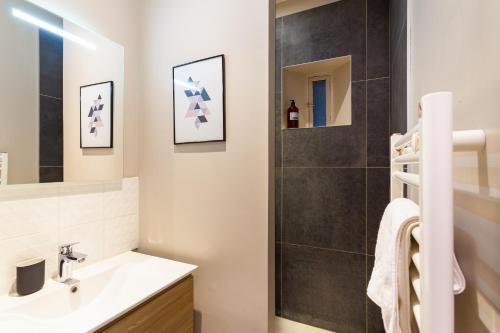une salle de bain avec un lavabo et une douche dans l'établissement Ruby, à Lyon