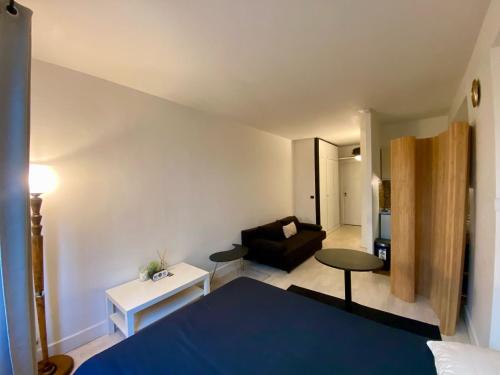 une chambre avec un lit et un salon avec un canapé dans l'établissement Studio Kennedy Passy Tour Eiffel, à Paris