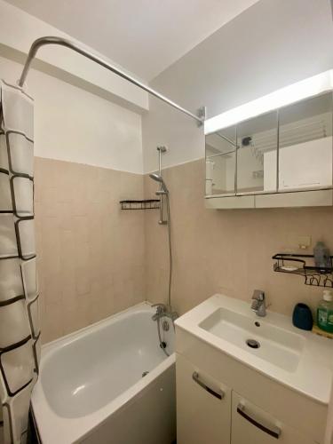 une salle de bain avec une baignoire blanche et un lavabo dans l'établissement Studio Kennedy Passy Tour Eiffel, à Paris