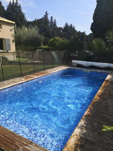 une piscine avec de l'eau bleue dans une cour dans l'établissement Air-conditioned house garden parking pool, à Rognonas