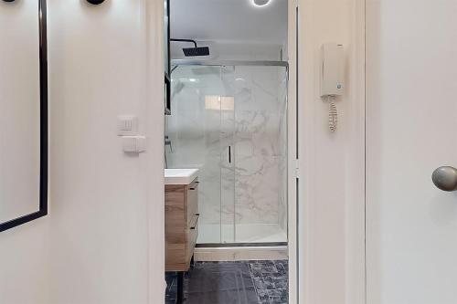 une salle de bain avec une douche avec une porte vitrée dans l'établissement Cozy home Near Paris Fully equipped & decorated, à Bondy