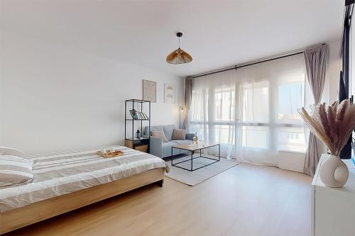 une chambre blanche avec un lit et une chaise dans l'établissement Cozy home Near Paris Fully equipped & decorated, à Bondy