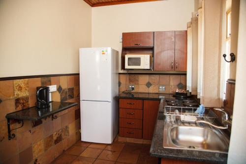 a kitchen with a white refrigerator and a sink at Blyde Canyon, A Forever Resort in Matibidi