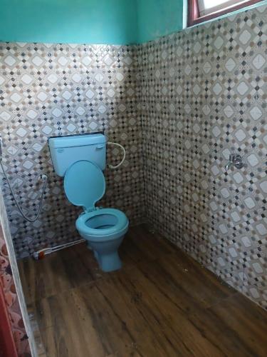 a bathroom with a blue toilet in a room at Yangzon Homestay By StayApart in Simāna Basti