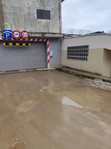 a parking lot with a garage with a puddle of water at Apartments Relax Tále in Evergreen Resort in Tale