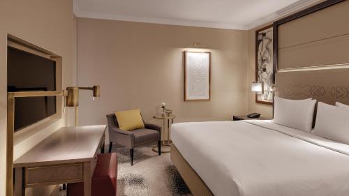 a hotel room with a bed and a desk and a chair at Hilton Munich City in Munich