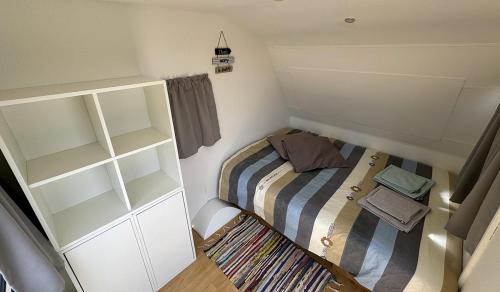 a small room with a bed and a book shelf at Vdb Lodge - coworking space - Work Relax & Sleep in Sobreda