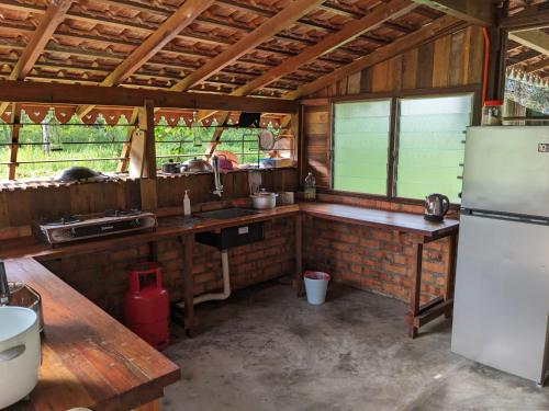 a kitchen with a white refrigerator and a table at Adventure Cottage in Gopeng