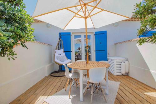 - une table et des chaises avec un parasol dans la chambre dans l'établissement Bord de mer, superbe studio tout confort, à Hyères
