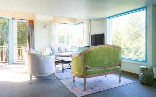 a living room with a green chair and a couch at Central location room #1, close town center in Queenstown