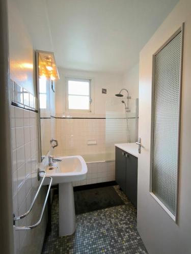 une salle de bain avec un lavabo, une douche et un miroir dans l'établissement Appartement 6 pers, 3 chambres, au 1er étage, d'une maison à Luz Saint Sauveur, Hautes-Pyrénées, à Luz-Saint-Sauveur
